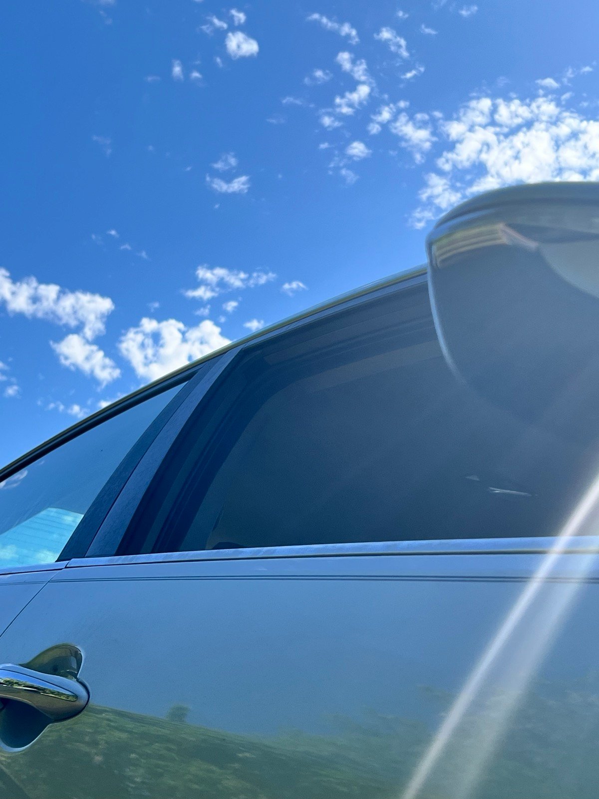 Blue sky and clouds reflected around a vehicle